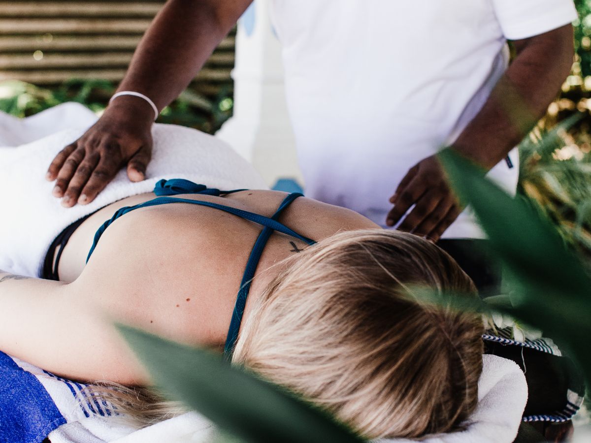 Massage enveloppant du dos dans une ambiance naturelle